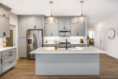 Open concept kitchen with cabinets painted a modern, contemporary light grey
